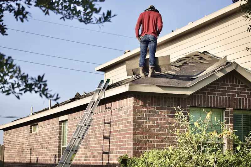 Professional roofer working on a residential roof in Fairchild